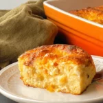 Freshly baked golden-brown cottage cheese bagels with a creamy, cheesy interior, served on a white plate.