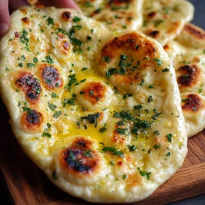 Freshly baked buttery garlic naan bread served with herbs.