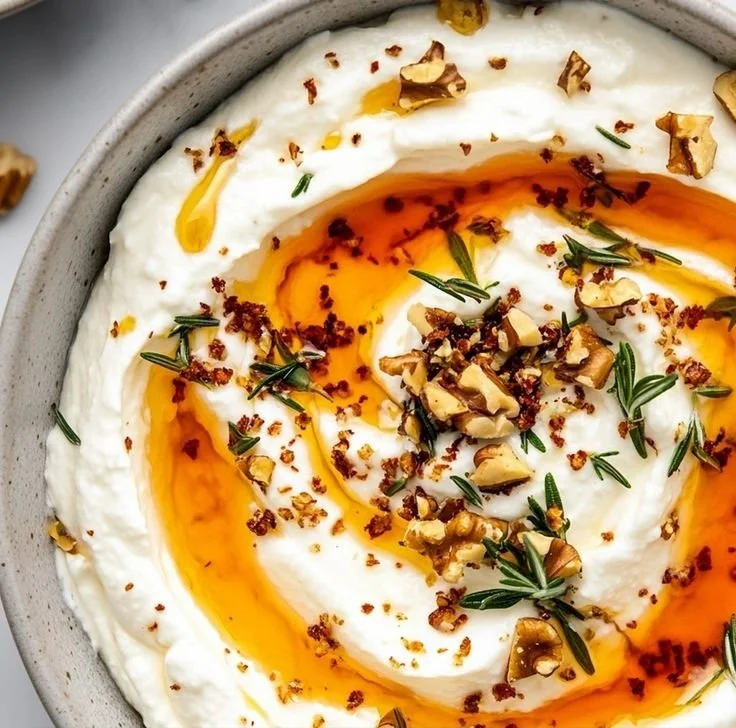 Delicious ricotta dip topped with hot honey, served in a bowl with crackers.