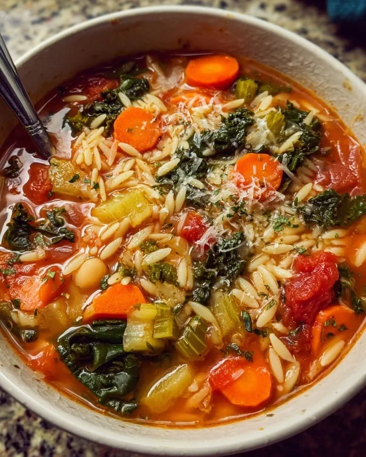 A bowl of delicious veggie orzo soup with colorful vegetables and orzo pasta.